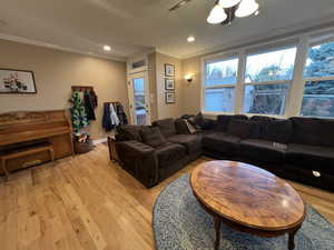 Living room with ornamental molding, a textured ceiling, recessed lighting, light wood finished floors, and ceiling fan