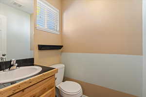 Bathroom featuring visible vents, vanity, and toilet