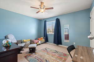 Bedroom featuring carpet floors, baseboards, and a ceiling fan