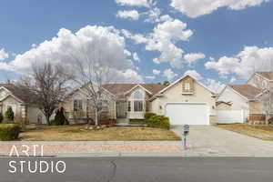 View of front of house with stucco siding, stone siding, fence, concrete driveway, and a garage