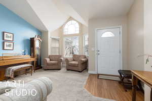 Entrance foyer featuring baseboards, wood finished floors, and vaulted ceiling