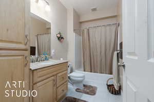 Full bathroom with vanity, visible vents, shower / tub combo, tile patterned floors, and toilet