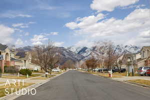 View of road featuring sidewalks, a mountain view, a residential view, and curbs