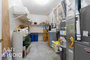 Storage room featuring strapped water heater and heating unit