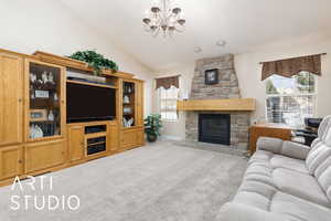 Living room with baseboards, carpet floors, a stone fireplace, a notable chandelier, and high vaulted ceiling