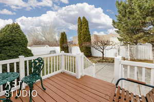 Wooden deck with a patio and a fenced backyard