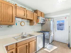 Kitchen with stainless steel appliances, light countertops, and a sink