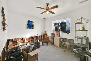 Interior space featuring unfinished concrete floors, a ceiling fan, and visible vents