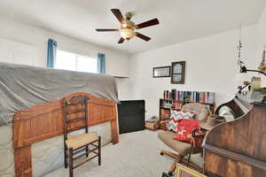 Carpeted bedroom featuring a textured ceiling and a ceiling fan