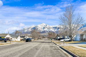 View of road featuring sidewalks, curbs, and a mountain view