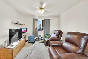 Living area featuring a ceiling fan and carpet flooring