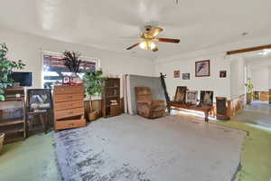 Sitting room featuring concrete flooring and ceiling fan