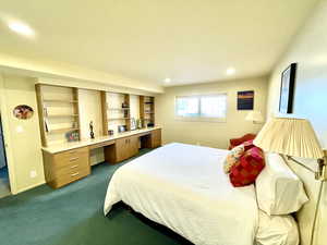 Bedroom featuring recessed lighting, built in study area, baseboards, and dark colored carpet