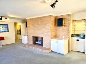 Unfurnished living room featuring visible vents and a brick fireplace