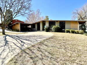 View of front of home featuring a carport and concrete driveway