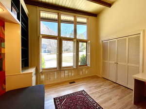 Interior space featuring visible vents, beamed ceiling, wood ceiling, and wood finished floors