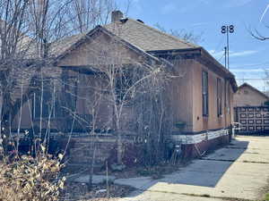 View of side of home featuring roof with shingles and a chimney