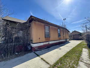 View of side of home with roof with shingles