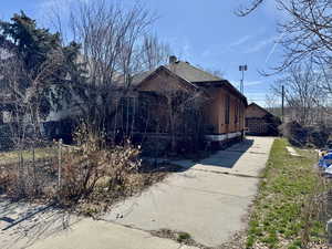 View of side of property with roof with shingles and fence