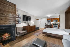 Bedroom with light wood finished floors and a large fireplace