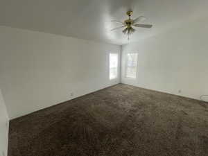 Carpeted spare room featuring a ceiling fan