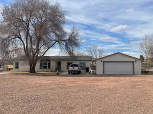Single story home featuring an outbuilding and a detached garage