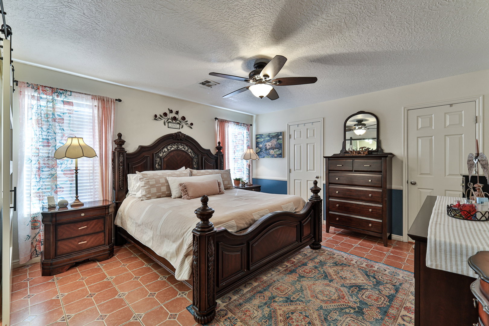 Bedroom with light tile patterned flooring, visible vents, a textured ceiling, and ceiling fan