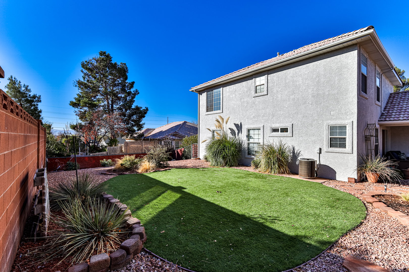 View of yard with central AC and fence