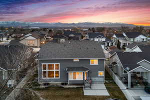 Back of house with a residential view, stucco siding, a mountain view, and roof with shingles