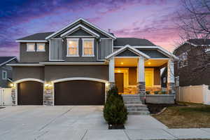 Craftsman house with concrete driveway, a garage, fence, and covered porch