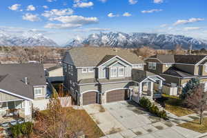 View of front of home featuring an attached garage, fence, a mountain view, and driveway