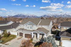 View of front facade featuring fence, a mountain view, driveway, and stucco siding