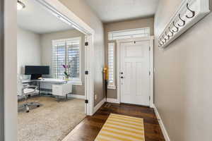 Foyer featuring baseboards and dark wood-style floors