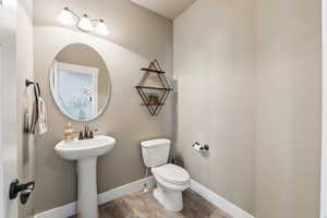 Bathroom with baseboards, toilet, and tile patterned flooring