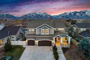 View of front of house with a mountain view, fence, a garage, and a gate