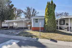 View of front of property with an attached carport and driveway