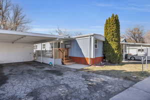 View of home's exterior featuring aphalt driveway and an attached carport