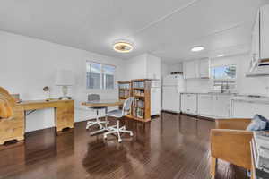 Office space with dark wood finished floors, baseboards, and a sink