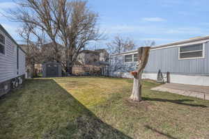 View of yard with an outdoor structure, a storage unit, and fence