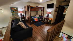 Bedroom featuring lofted ceiling, a textured ceiling, and wood finished floors