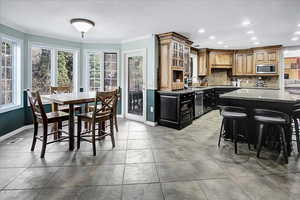 Kitchen featuring ornamental molding, baseboards, tasteful backsplash, and stainless steel appliances