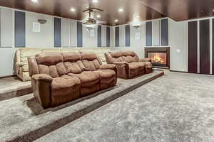 Cinema room with a glass covered fireplace, recessed lighting, visible vents, and carpet