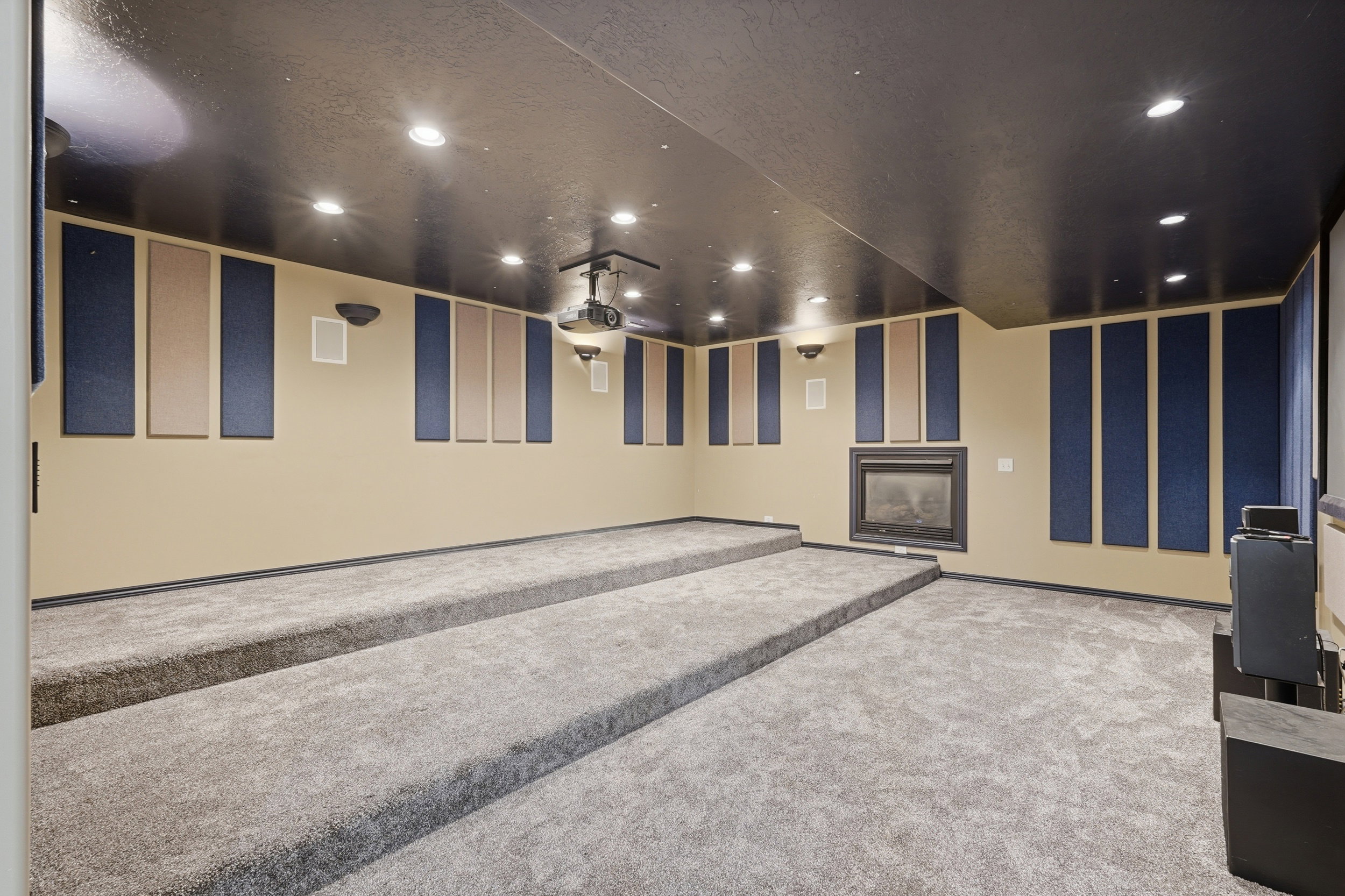 Home theater room featuring carpet, recessed lighting, and a fireplace