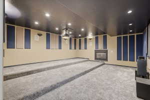 Home theater room featuring carpet, recessed lighting, and a fireplace