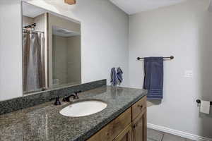 Full bathroom featuring tile patterned flooring, vanity, a shower with shower curtain, and baseboards