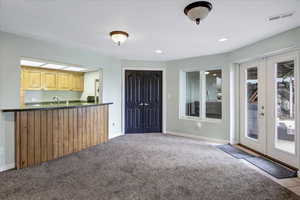 Kitchen featuring visible vents, dark countertops, french doors, carpet floors, and baseboards