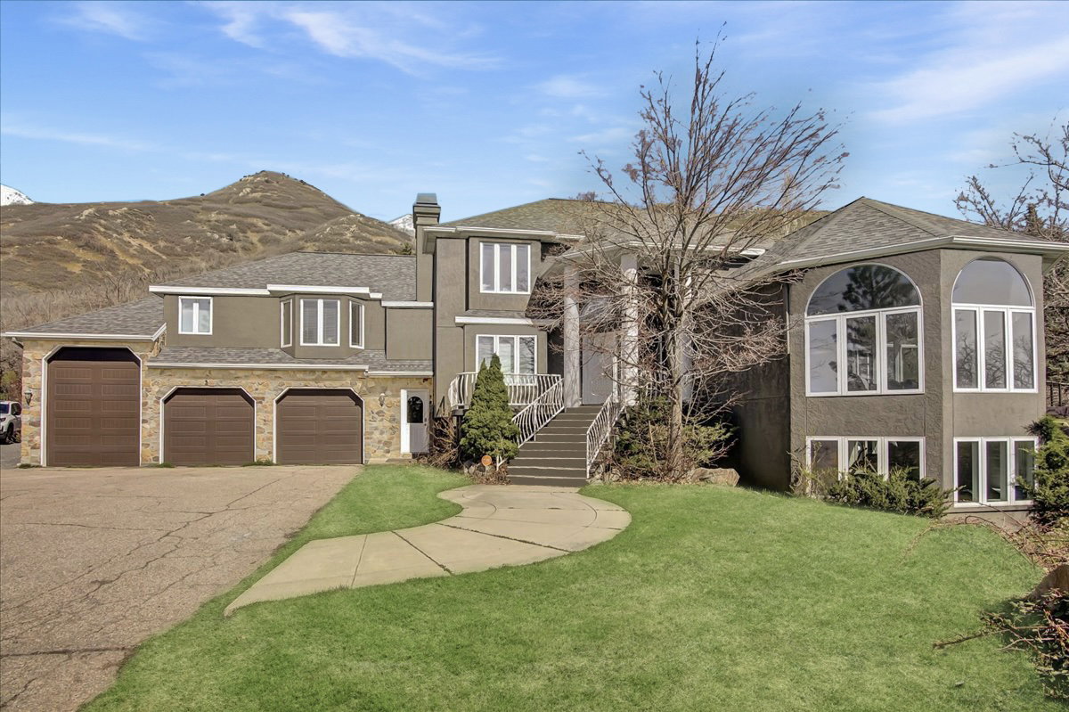 View of front of property featuring a front lawn, a chimney, and driveway with 3 car garage