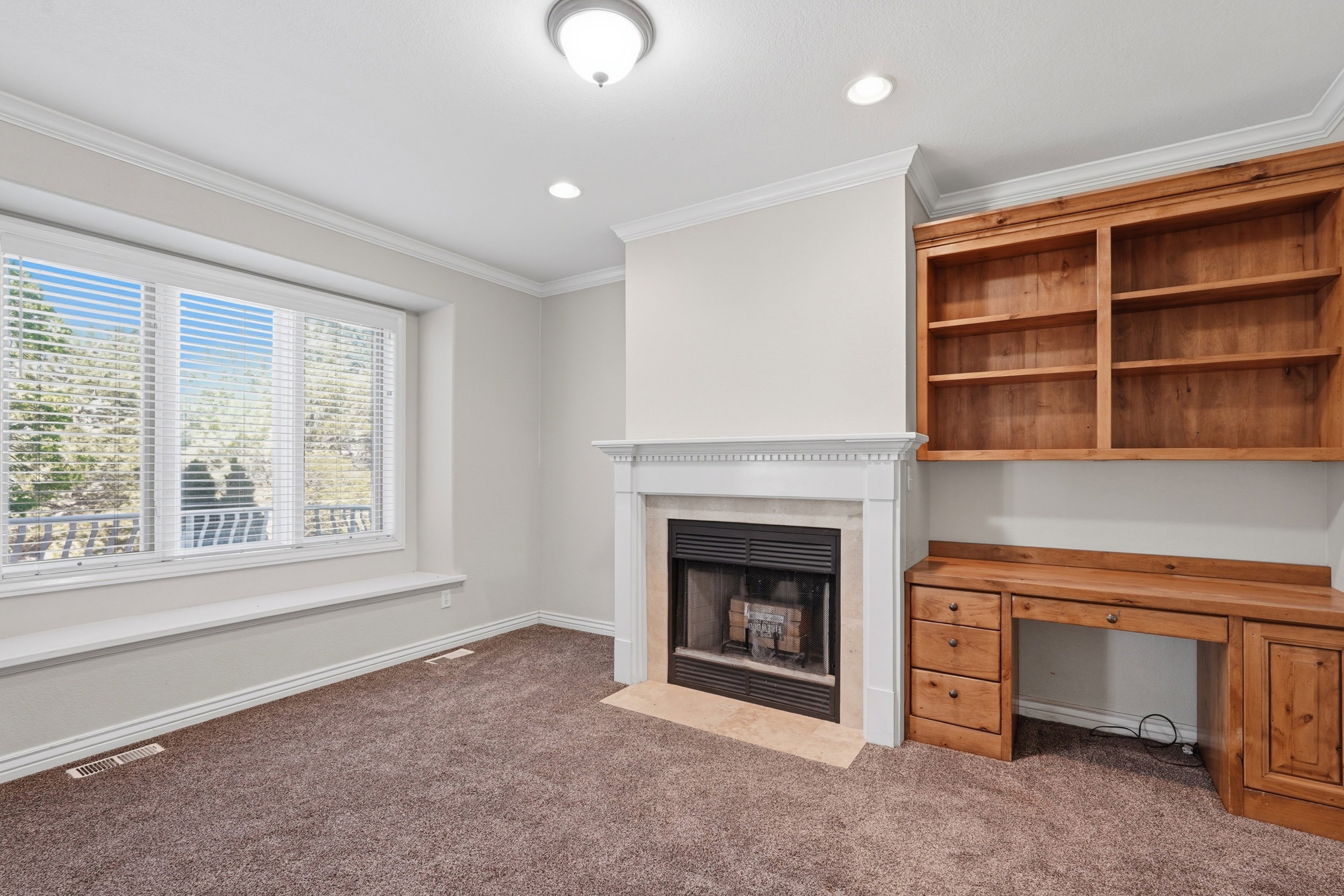 Private office off of foyer with fireplace and built-in shelves