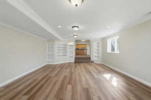 Unfurnished living room with wood finished floors, built-in shelves
