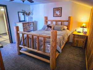 Carpeted bedroom featuring a ceiling fan and a textured ceiling